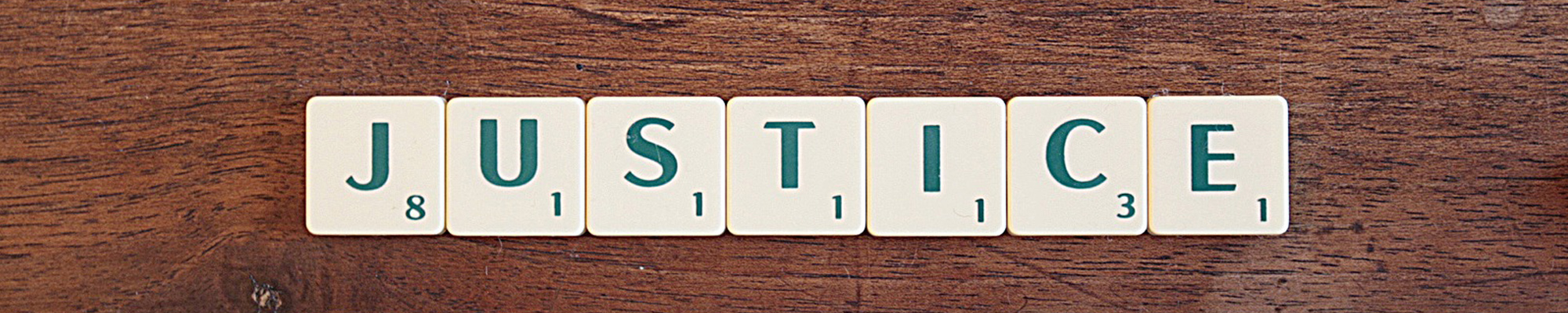 scrabble tiles that spell Justice