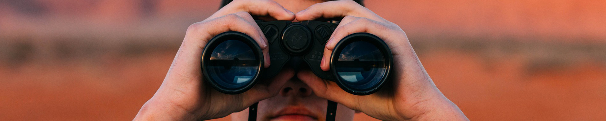 man looking through binoculars